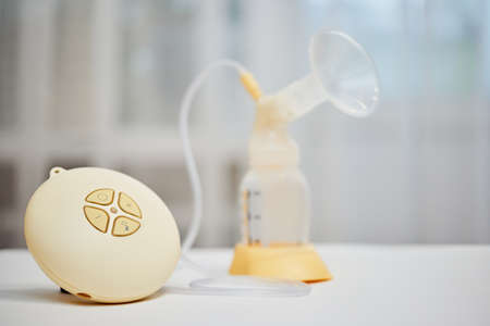Breast pump with empty baby bottle on tableの写真素材