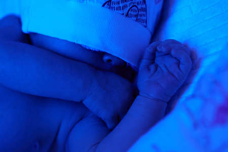 New born baby under the ultraviolet lamp.の写真素材
