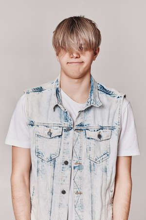 Handsome young man with trendy hairstyle posingの写真素材