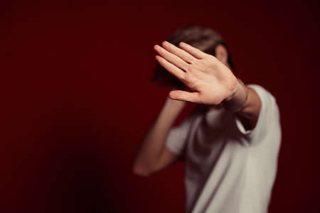 young man in white t-shirt showing stop gesture at cameraの写真素材