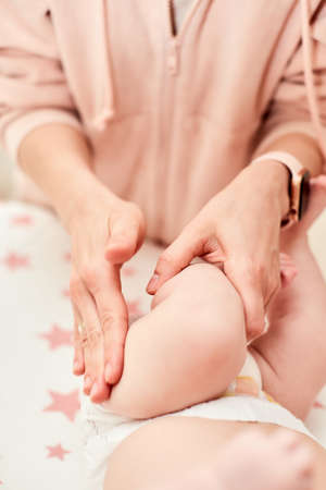 Mom or therapist giving massage to child at homeの写真素材