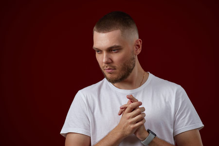 handsome man in a white t-shirt thinks about somethingの写真素材