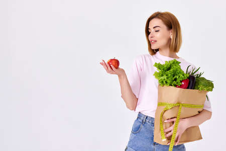 caucasian woman hold paper bag with vegetablesの写真素材
