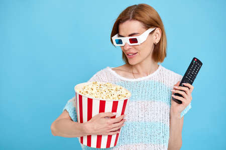 woman watching movie film, holding bucket of popcorn