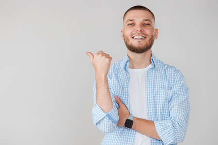 Young handsome bearded man pointing to the sideの写真素材