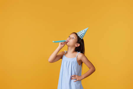 happy little birthday girl with party cone hat and whistle