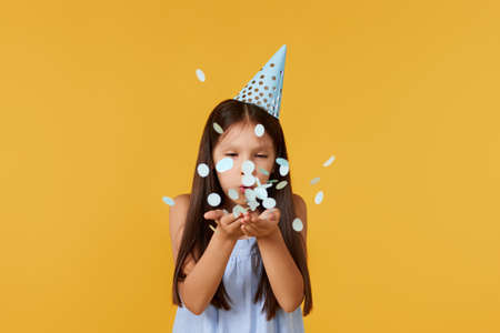 birthday child girl blowing confetti off her handsの写真素材