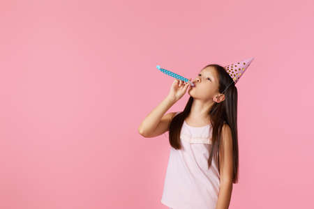 happy little birthday girl with party cone hat and whistleの写真素材