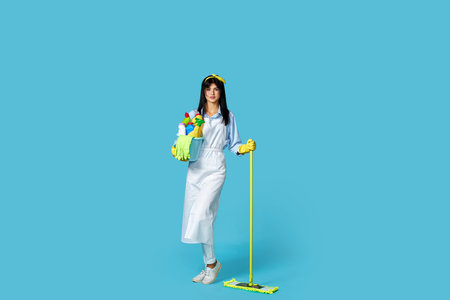 woman in rubber gloves and cleaner apron with cleaning suppliesの写真素材