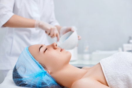 beautiful young woman patient with professional cosmetologistの写真素材