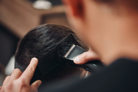 Barber shaving caucasian man in barber shopの写真素材