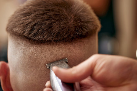 Barber shaving caucasian man in barber shopの写真素材