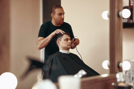 Barber shaving caucasian man in barber shopの写真素材