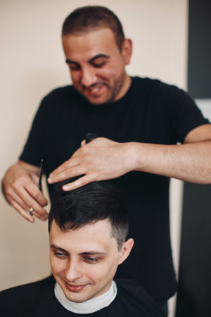hairdresser does haircut for man in barber shopの写真素材