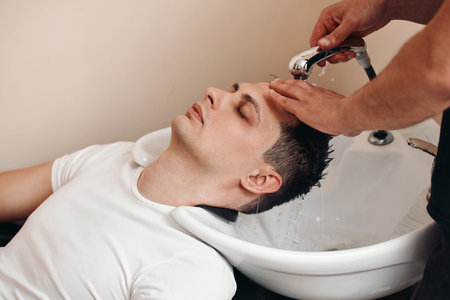 Barber washing hair of caucasian man , close-upの写真素材