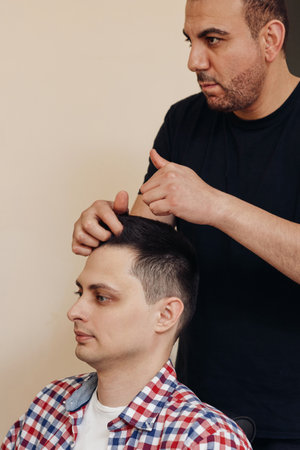 Barber and satisfied bearded man in front of the mirrorの写真素材