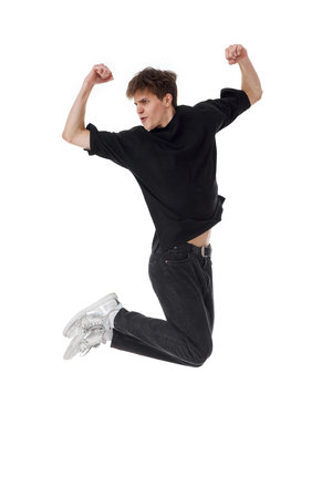 young man in black t-shirt smiling jumping high