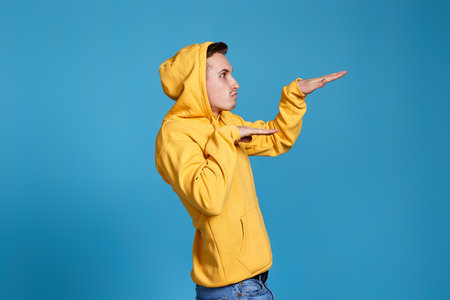 positive funny man in yellow sweatshirt dancingの写真素材