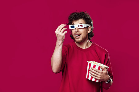 handsome bearded man in 3d-glasses, t-shirt showing popcorn