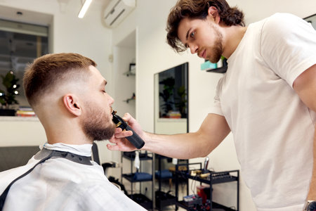 Barber shaving bearded man in barber shop.の写真素材