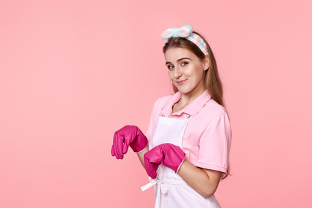 young woman in rubber gloves and cleaner apronの写真素材