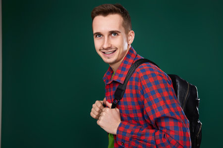 cheerful handsome man in red plaid shirt with backpack
