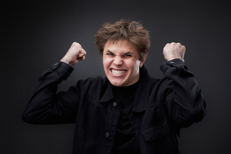 annoyed angry man in furious gesture on black background