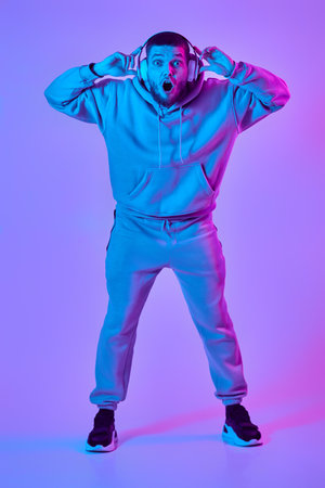 man with headphones in sweatshirt enjoying favorite musicの写真素材