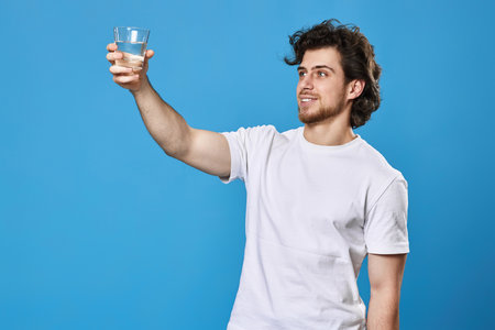Young handsome man with drinking glass of waterの写真素材