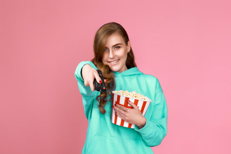 woman in 3d glasses with remote control holding bucket of popcornの写真素材