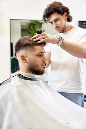 Barber trim hair with clipper on handsome bearded manの写真素材