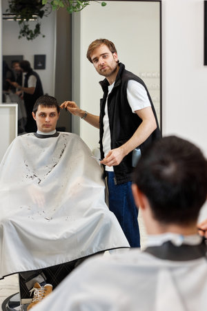 hairdresser does haircut for caucasian bearded manの写真素材