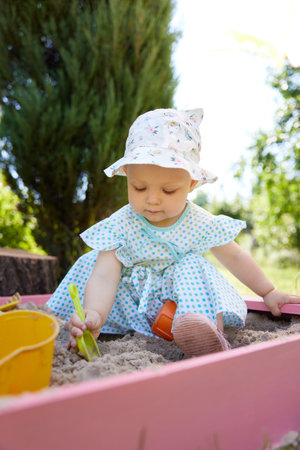 baby girl playing in sand on outdoor playgroundの写真素材