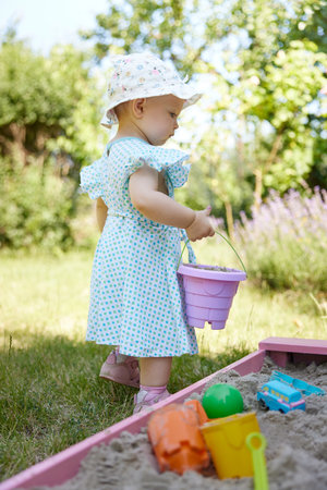 baby girl playing in sand on outdoor playgroundの写真素材