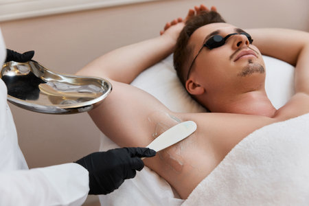 young man undergoes procedure of arm pit laser epilationの写真素材