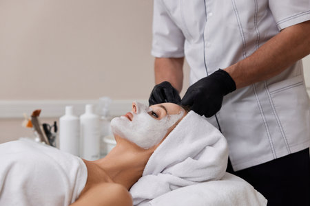 beautician cleanses skin of woman with cotton sponge. .の写真素材