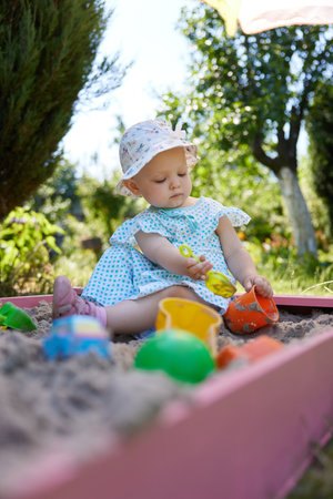 baby girl playing in sand on outdoor playgroundの写真素材