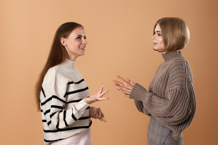 Two cheerful attractive women friends talking togetherの写真素材