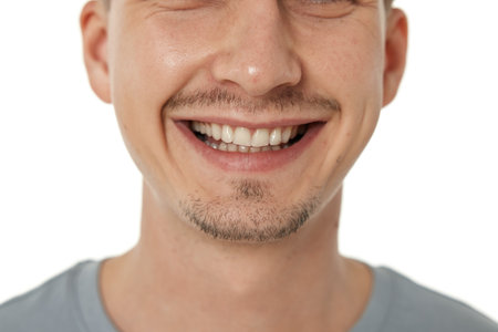 mouth and teeth of smiling man on studio background. male face with clean teethの写真素材