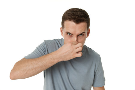 young man shows her toung, feels disgust on white background.の写真素材