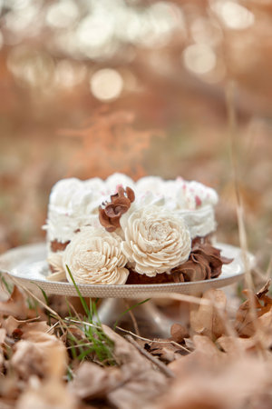 wedding cake with flowers on autumn fallen leaves outdoorの写真素材