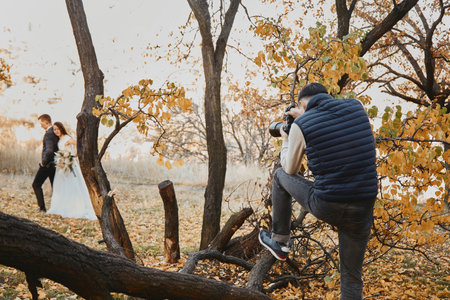Professional wedding photographer taking pictures of the bride and groomoutdoorの写真素材