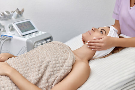 Beautiful woman receiving facial massage in beauty salon. Skin care.の写真素材