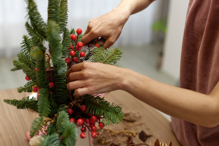 Woman making Christmas arrangement with fir branches. craft handmade decor.の写真素材