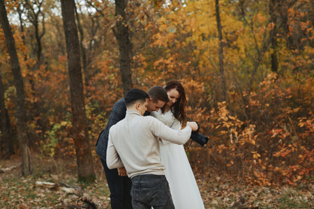 wedding photographer shows just taken photos to wedding couple. bride and groom in natureの写真素材