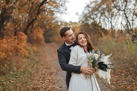 happy bride and groom enjoying romantic moments outside in autumnの写真素材