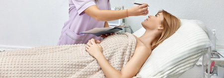 cosmetologist marking skin of caucasian woman with white pencil. facial marking for aesthetic procedure.の写真素材