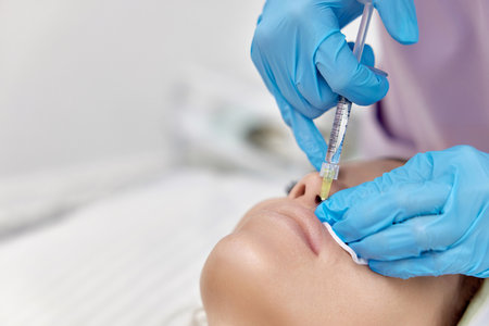 beautician makes injections to enlarge the lips of beautiful woman. procedure lip augmentationの写真素材