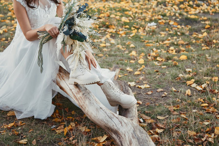 bride wearing white boots holding beautiful autumn bouquet. copy spaceの写真素材