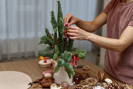 Woman making Christmas arrangement with fir branches. craft handmade decor.の写真素材
